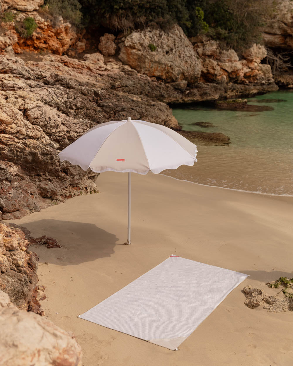 sombrilla y toalla beige flamingueo