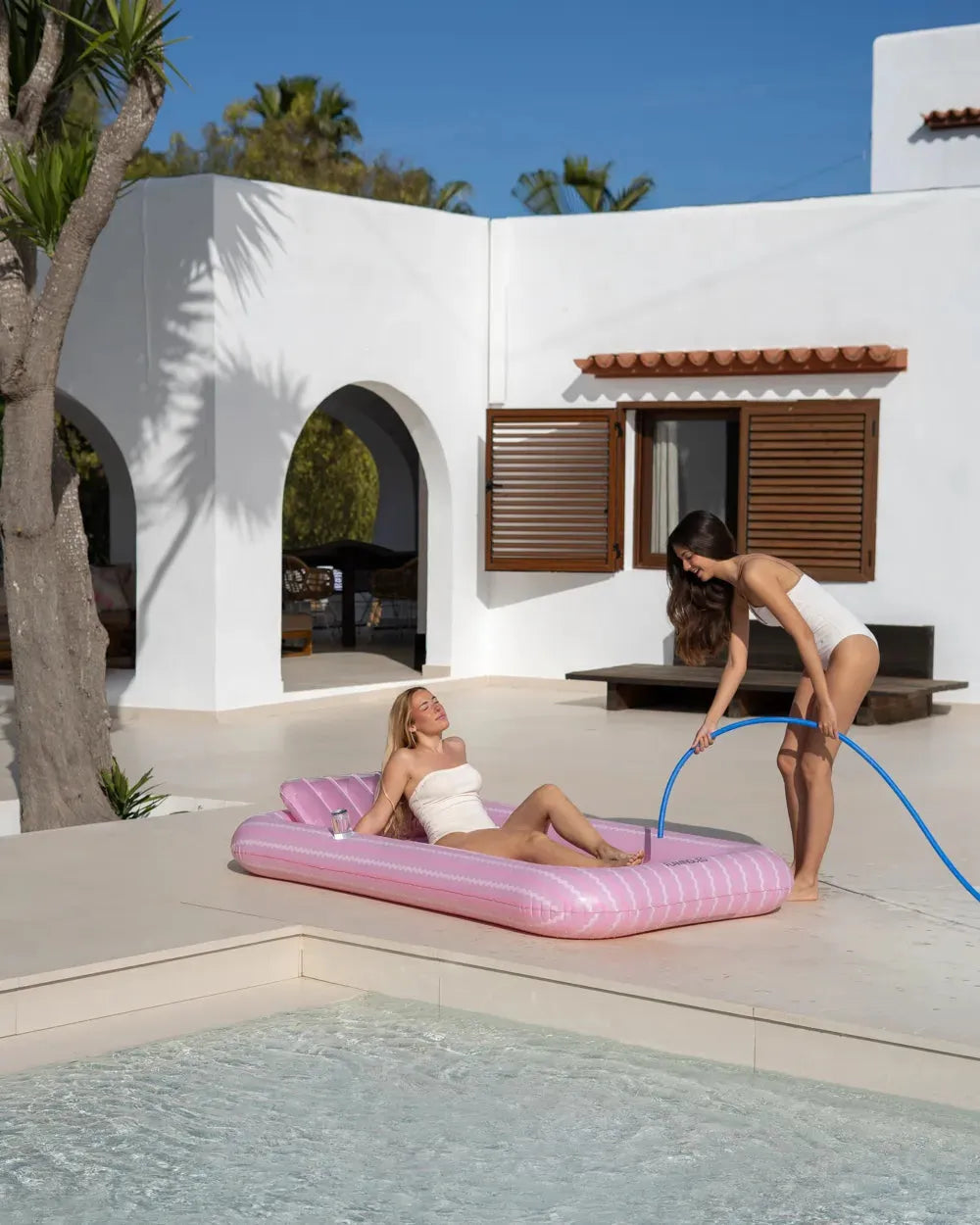 Flotador rosa individual junto a piscina